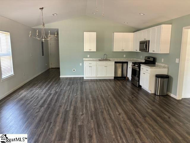 kitchen with dark wood-type flooring, white cabinetry, stainless steel appliances, and light countertops