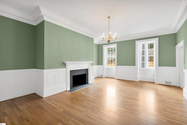 unfurnished living room with ornamental molding and light hardwood / wood-style flooring