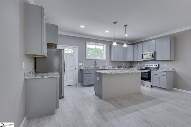 kitchen with stainless steel appliances, a kitchen island, and gray cabinets