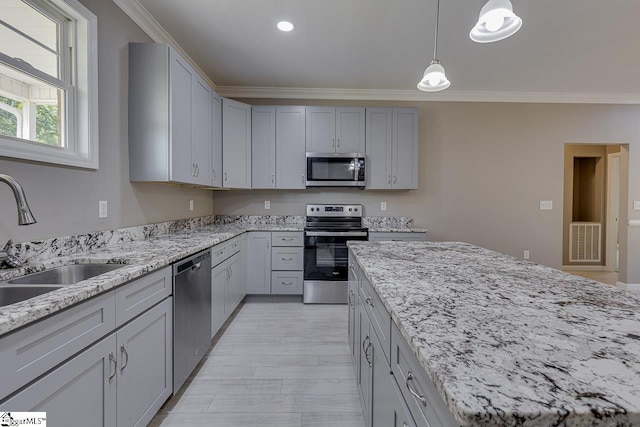 kitchen with sink, crown molding, appliances with stainless steel finishes, gray cabinetry, and decorative light fixtures