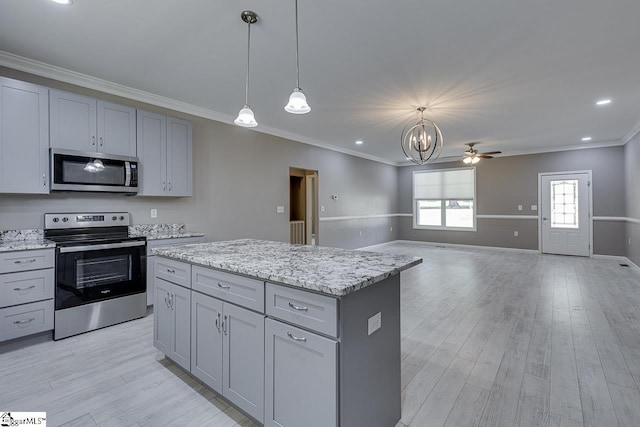 kitchen featuring pendant lighting, gray cabinets, a center island, and appliances with stainless steel finishes