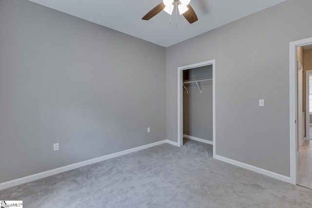 unfurnished bedroom featuring light carpet, a closet, and ceiling fan