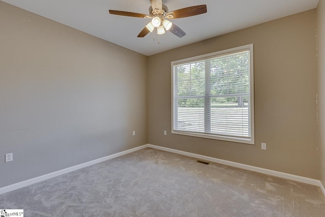 spare room featuring light colored carpet and ceiling fan