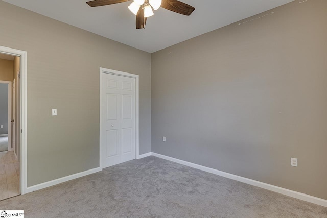 unfurnished bedroom with light carpet, ceiling fan, and a closet