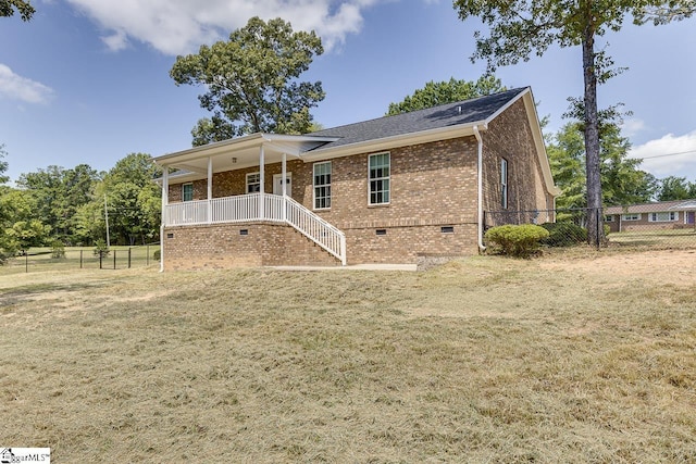 rear view of property featuring a porch and a yard