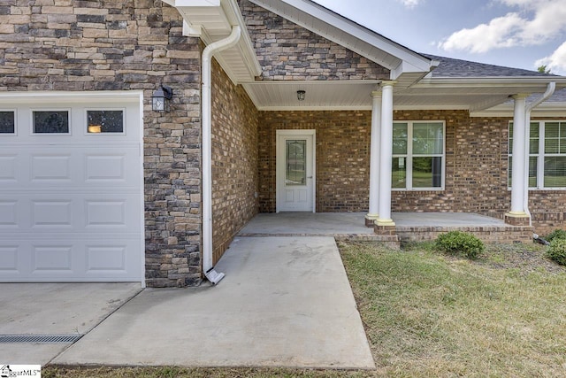 view of exterior entry with a garage and covered porch