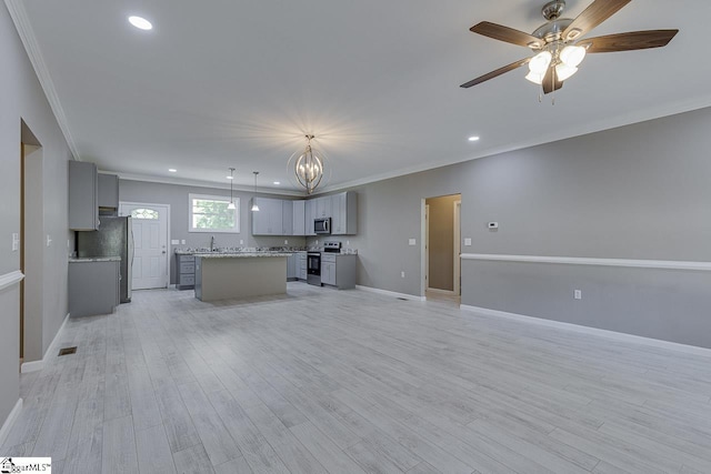 kitchen featuring gray cabinetry, pendant lighting, a center island, and appliances with stainless steel finishes