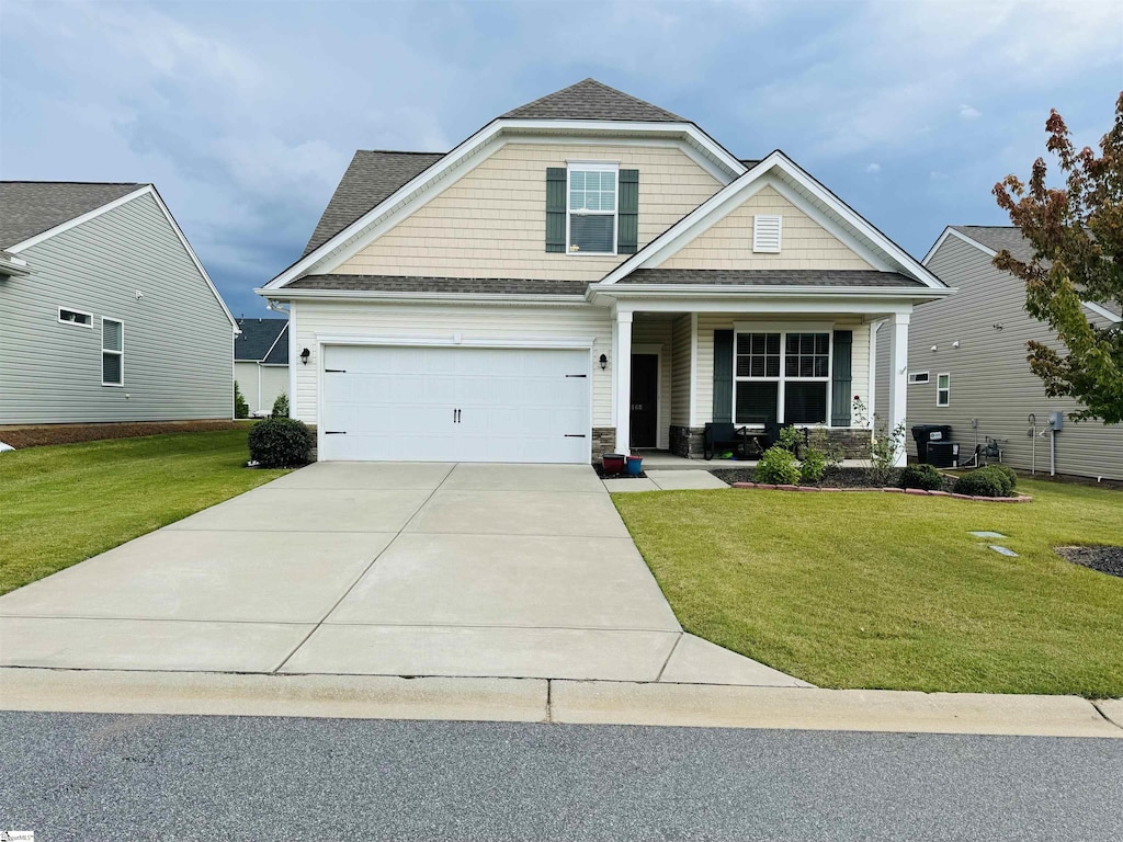 craftsman-style home featuring a porch, a garage, and a front lawn