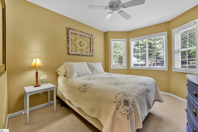 bedroom with multiple windows, light carpet, and ceiling fan