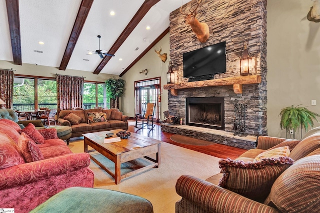 living room with beamed ceiling, high vaulted ceiling, hardwood / wood-style flooring, and a fireplace