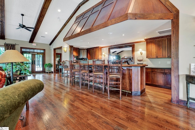 kitchen featuring hardwood / wood-style flooring, ceiling fan, high vaulted ceiling, and beam ceiling