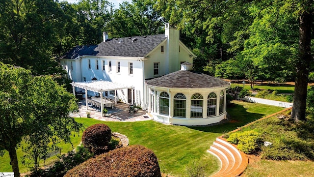 rear view of property featuring a lawn and a patio