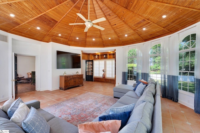 living room with ceiling fan, light tile patterned flooring, wood ceiling, and a high ceiling