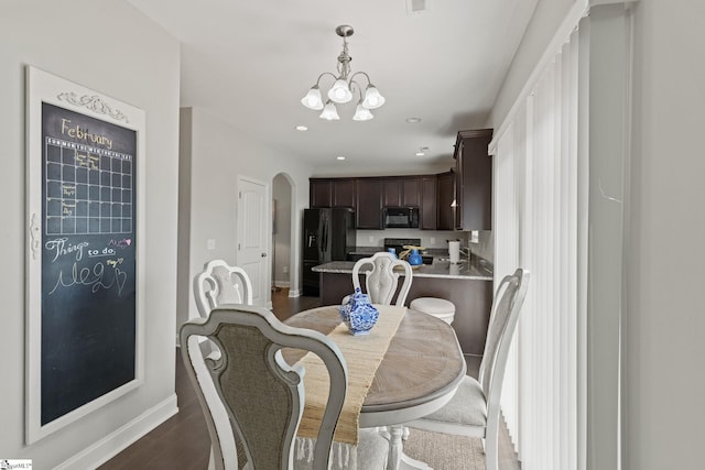 dining room featuring dark wood-type flooring and a notable chandelier