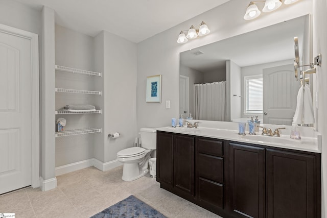 bathroom featuring tile patterned flooring, vanity, and toilet