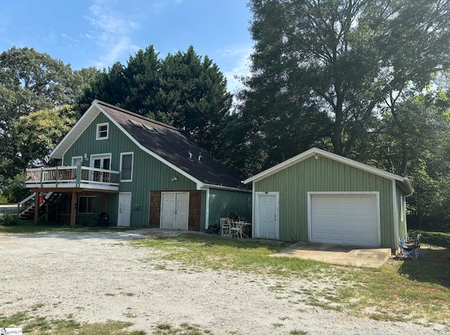 view of front facade with a garage, a wooden deck, and an outdoor structure