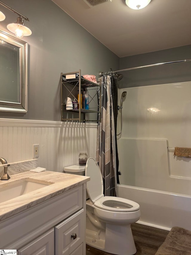 full bathroom featuring hardwood / wood-style flooring, shower / bath combo, toilet, and vanity