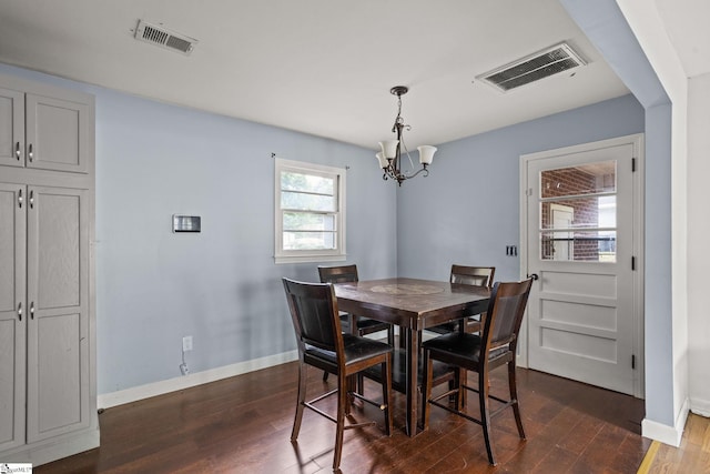 dining area featuring dark wood-type flooring and a chandelier