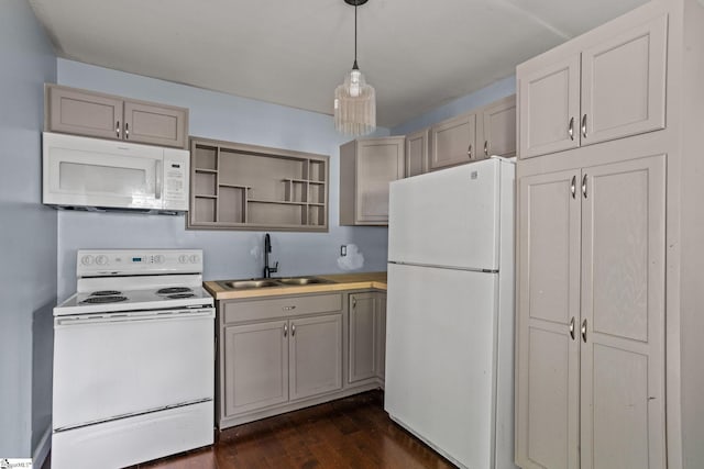 kitchen featuring pendant lighting, white appliances, dark wood-type flooring, and sink