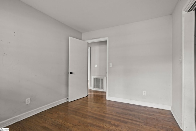 unfurnished room with dark hardwood / wood-style flooring