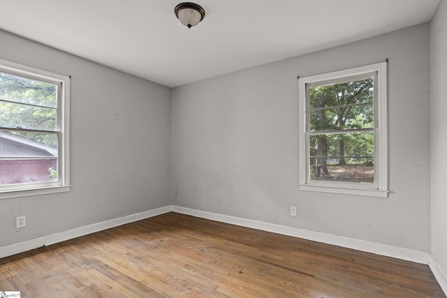 unfurnished room with hardwood / wood-style flooring and a healthy amount of sunlight