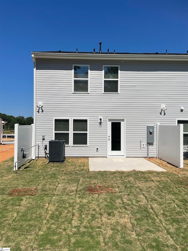 rear view of property featuring a yard, a patio, and central air condition unit