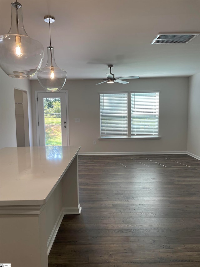 kitchen with dark hardwood / wood-style floors, ceiling fan, and decorative light fixtures