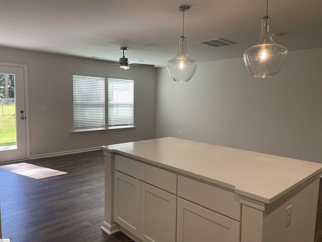 kitchen with hanging light fixtures, dark wood-type flooring, white cabinets, and ceiling fan