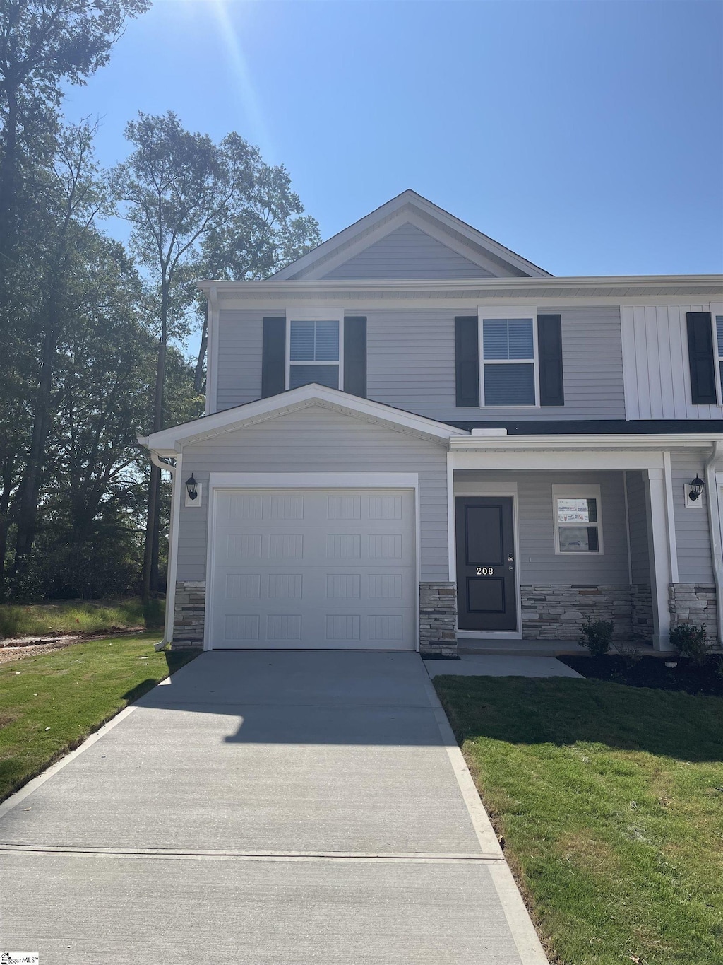 208 Kai Trl, Fountain Inn, SC 29644 - view of front of house featuring driveway, stone siding, a front lawn, and board and batten siding