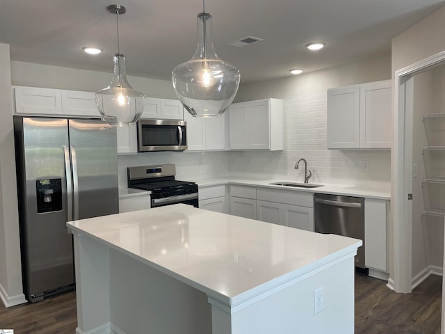 kitchen with sink, white cabinets, a center island, and stainless steel appliances