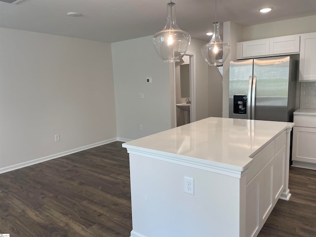 kitchen featuring stainless steel refrigerator with ice dispenser, backsplash, white cabinets, and a center island