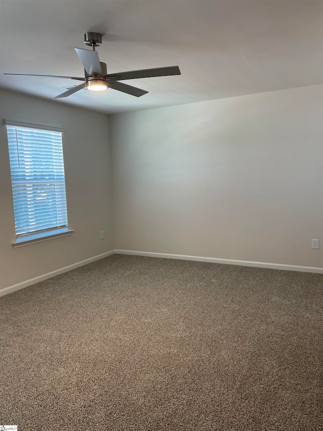 carpeted spare room with ceiling fan