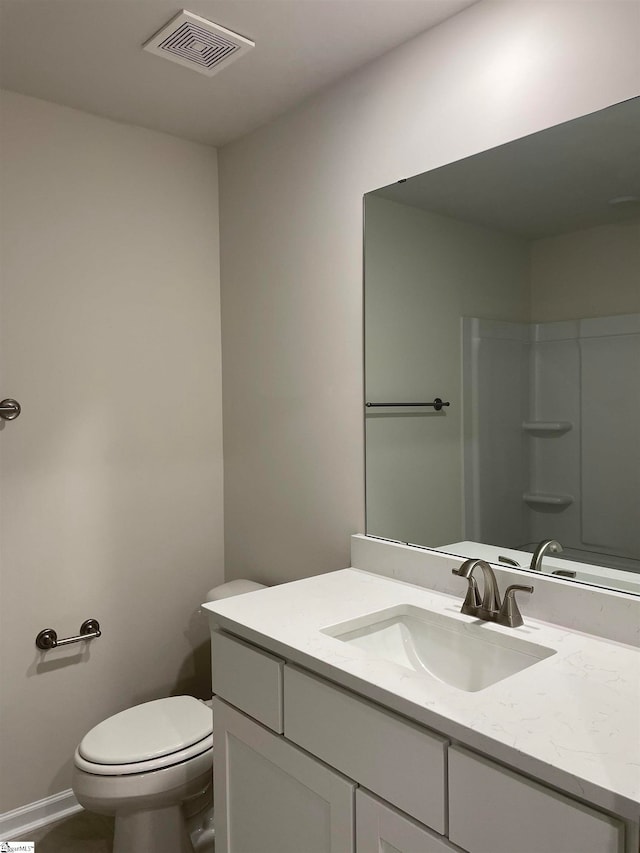 bathroom featuring toilet, a shower, and vanity