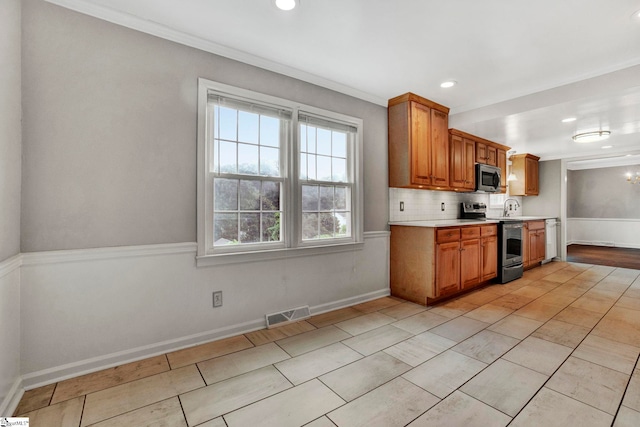 kitchen with stainless steel appliances, visible vents, light countertops, decorative backsplash, and brown cabinetry