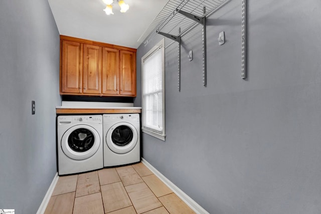 laundry area featuring washer and clothes dryer, cabinet space, and baseboards