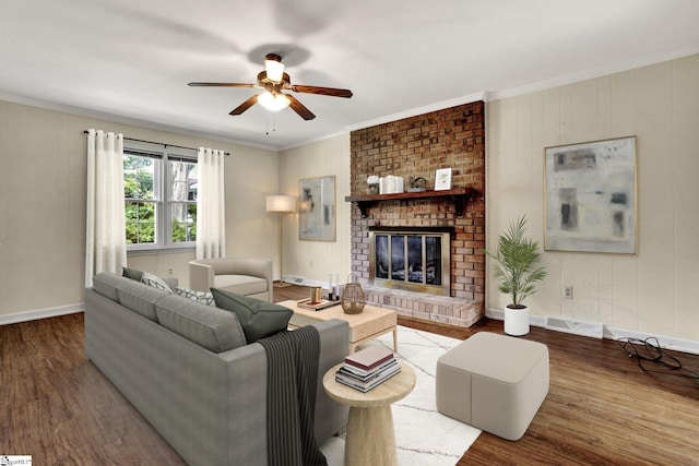 living room with hardwood / wood-style flooring, crown molding, ceiling fan, and a fireplace