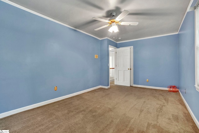 carpeted spare room with crown molding and ceiling fan