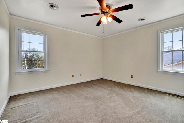 carpeted spare room featuring crown molding and ceiling fan