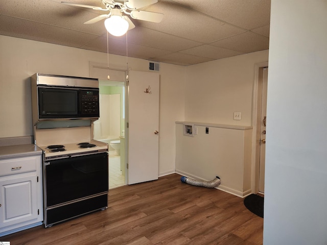 kitchen with wood finished floors, visible vents, white cabinetry, light countertops, and black appliances