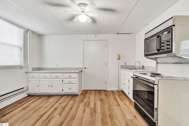 kitchen featuring black microwave, a sink, white cabinetry, light countertops, and electric stove