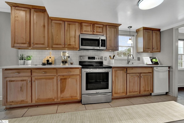 kitchen featuring sink, light tile patterned floors, appliances with stainless steel finishes, backsplash, and decorative light fixtures