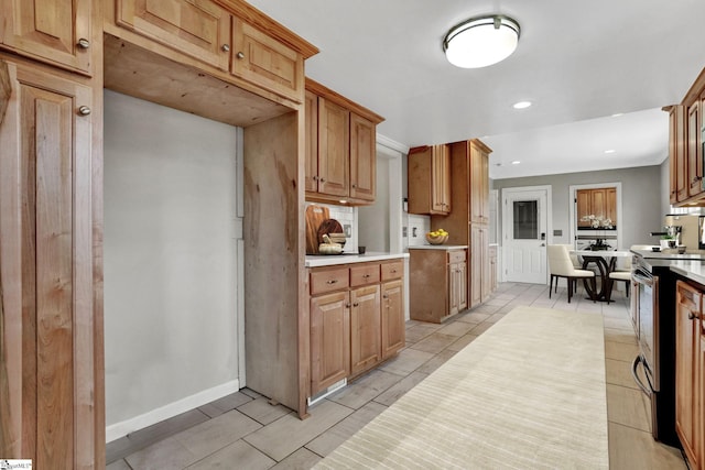 kitchen featuring tasteful backsplash, baseboards, light countertops, stainless steel range with electric stovetop, and recessed lighting