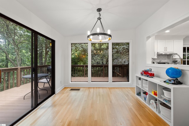 sunroom featuring a chandelier and vaulted ceiling