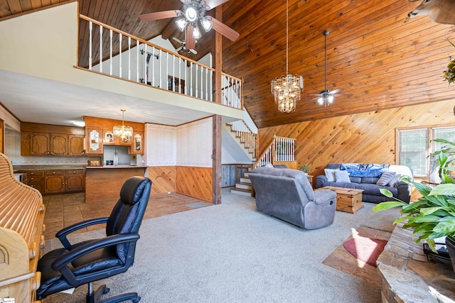 carpeted office featuring wooden walls, ceiling fan with notable chandelier, and high vaulted ceiling