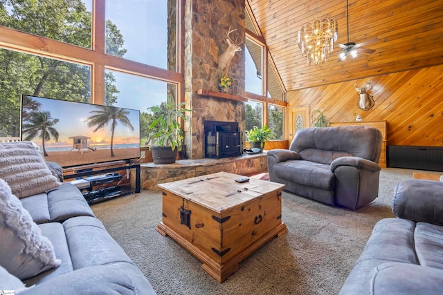 carpeted living room featuring high vaulted ceiling, a wood stove, a wealth of natural light, and wooden walls