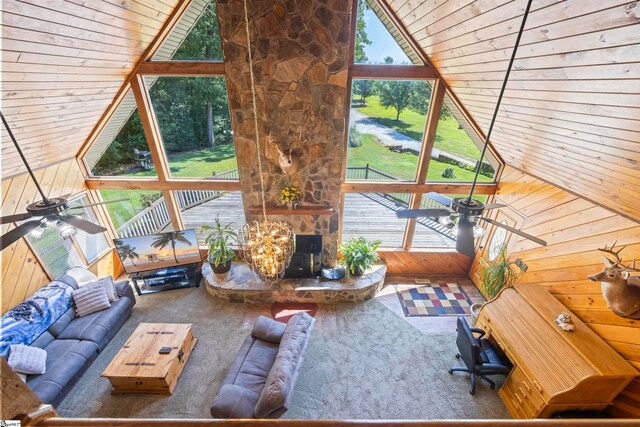 unfurnished living room featuring wooden walls, carpet floors, lofted ceiling, and ceiling fan