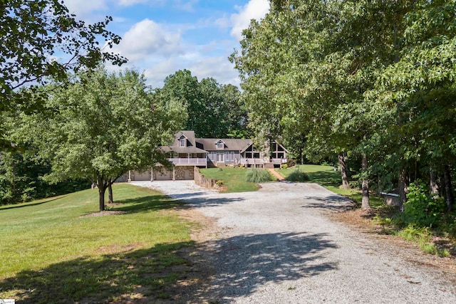 view of front of home featuring a deck, a front yard, and a garage