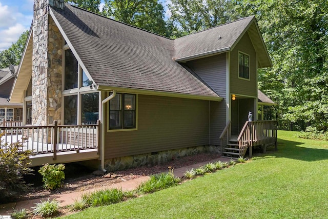 rear view of house with a wooden deck and a yard