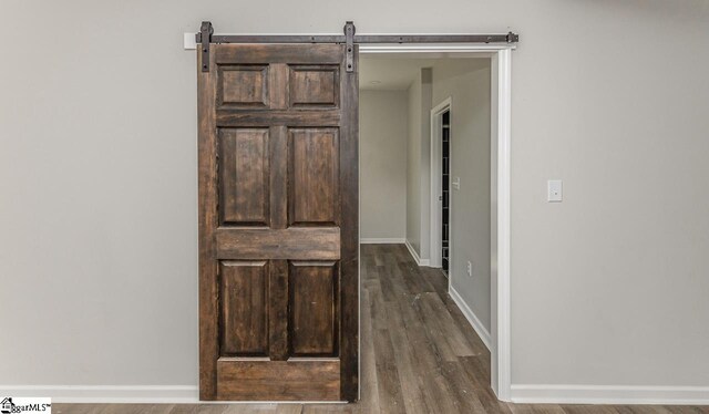 hall featuring dark hardwood / wood-style floors and a barn door