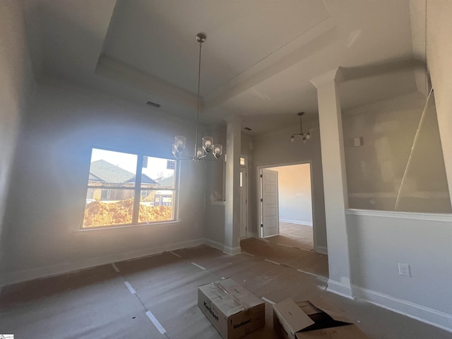 unfurnished dining area featuring a chandelier, a tray ceiling, visible vents, and baseboards